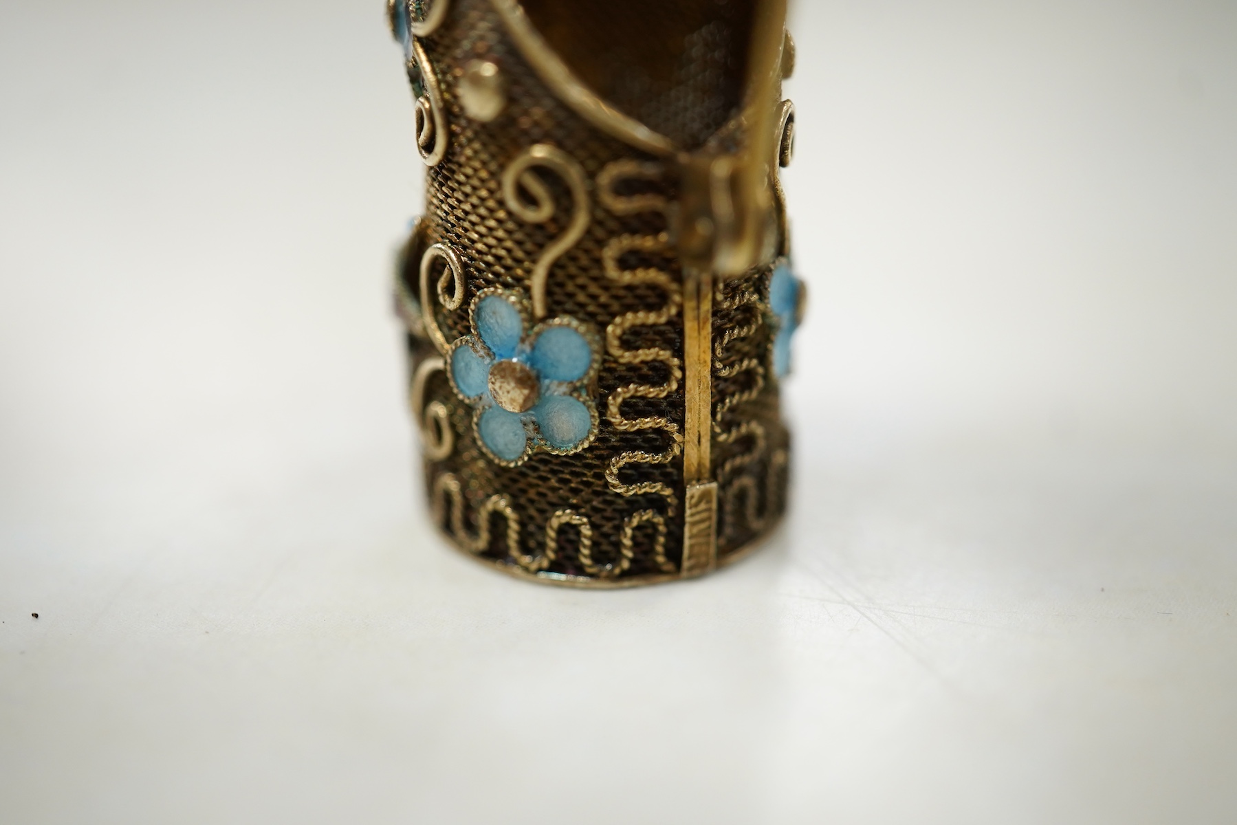 A Chinese silver gilt coral and turquoise nail guard brooch, composed of filigree, set with coral and turquoise cabochons, applied with foliate designs in blue enamel, length 8.4cm, stamped SILVER, Condition: in good con